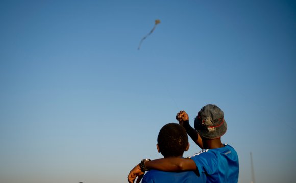 Two kids flying a kite