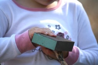 kids using sanding blocks and sandpaper